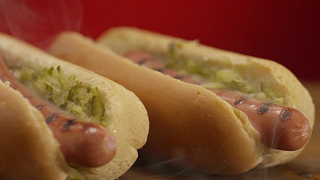 Appetizing steaming hot dog on red background. Shot on RED EPIC DRAGON Cinema Camera.