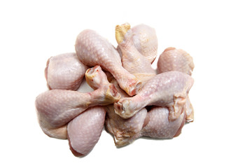 Raw Chicken drumstick rests on a white background.