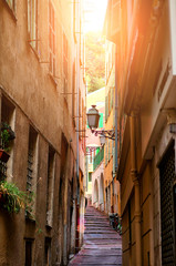 Fototapeta na wymiar Beautiful view of scenic narrow alley street with historic traditional houses in an old town in Europe with blue sky and clouds in summer sunny day, with retro vintage Instagram warm filter effect
