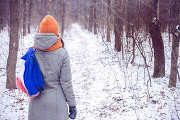 Fototapeta na wymiar Woman walking in winter woods.