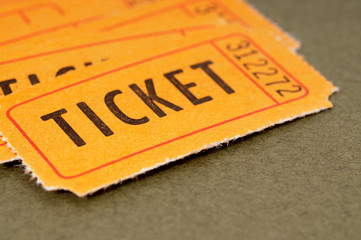Several heap pile old vintage retro orange ticket stub for raffle movie concert theater torn damaged worn used isolated on plain brown background photo