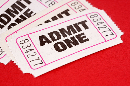 Several pile heap white admit one ticket stub for movie or theater entrance admission isolated on a red background photo