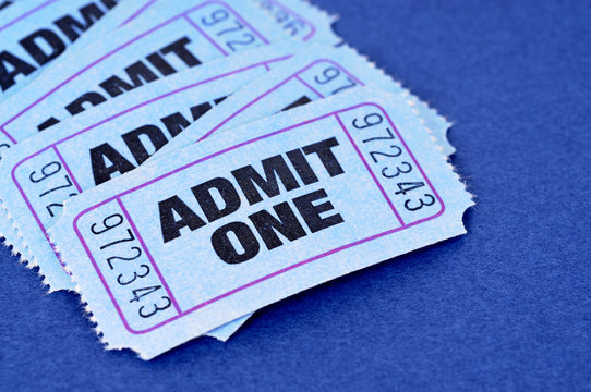 Several pile heap blue admit one ticket stub for movie or theater entrance admission isolated on a plain background photo