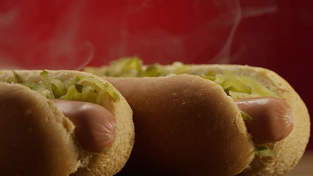 Appetizing steaming hot dog on red background. Shot on RED EPIC DRAGON Cinema Camera.