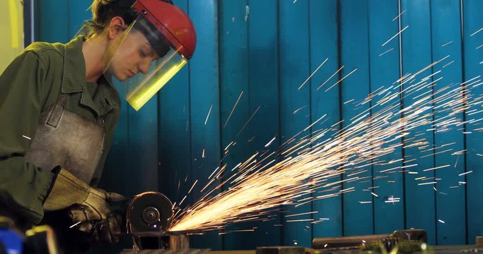 Female welder working at work shop