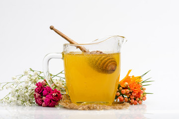 Honey jar with spoon and flowers. Isolated on pure white