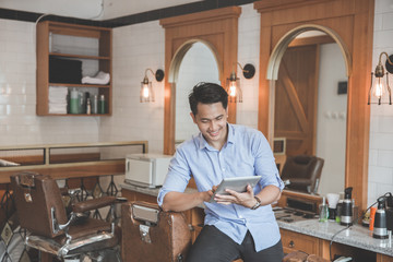 man in barbershop with digital tablet