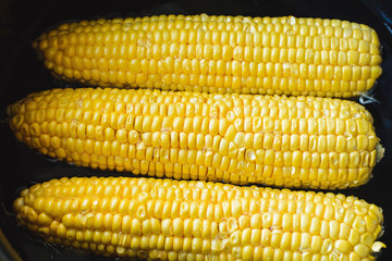 golden corn in black bowl top view