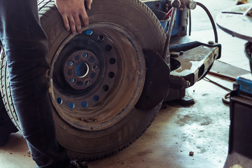 mechanic changing tire with bead breaker tool