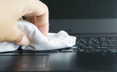 man hands cleaning laptop computer screen with cloth
