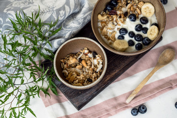 brunch : home made yogurt with granola and banana in wooden bowl.

