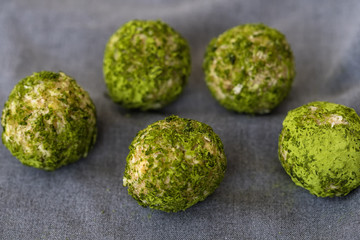 Sweets of green color, balls with addition of matcha of tea, healthy nutrition, crude food, crude candies with addition of matcha of tea