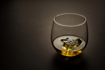 glass of whiskey shot against a dark background