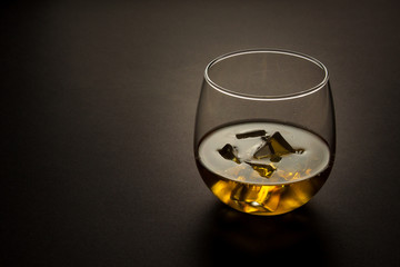 glass of whiskey shot against a dark background
