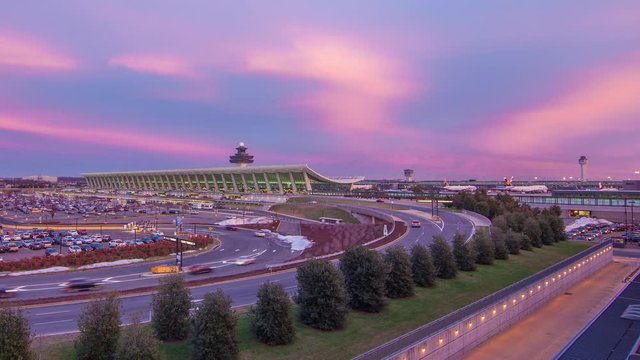 Washington DC Dulles International Airport Timelapse with Vehicle Traffic Entering towards Iconic Terminal Building at Vibrant Colored Sunset and Departing Jet Airliners