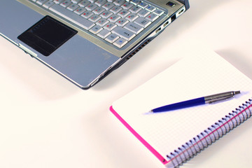 Office table with blank notepad and laptop 