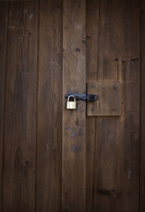 Old weathered wood planks doors with old rusty lock. Texture for background.