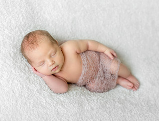 lovely sleeping baby covered with light knitted shawl