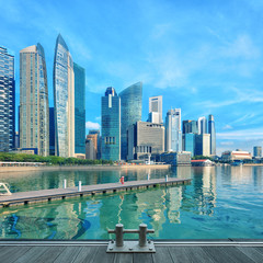 Naklejka premium Singapore central quay with water on foreground. Modern city architecture at sunny day with wooden decks on foreground