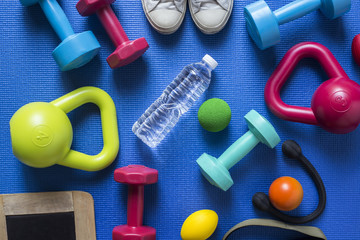 fitness tools on blue yoga mat background