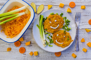 Fried fritters with pumpkin with green onions and spices on wooden background. 