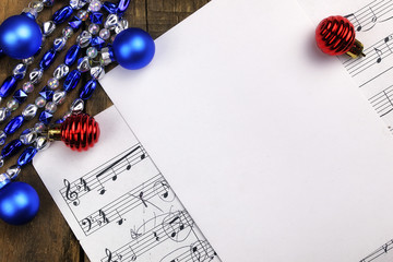 Christmas tree decorations on the table and sheet with music not