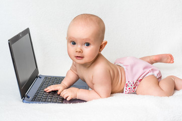 Cute baby typing on a laptop computer isolated on white