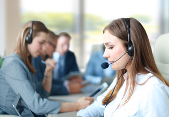 Portrait of call center worker accompanied by her team. Smiling customer support operator at work.