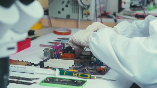 Some computer USB port components over motherboard background. Repair of laptops and computer motherboards. computer repair wizard examines laptop motherboard, using a screwdriver. Motherboard.