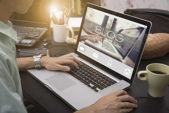 Business Hand Typing On A Laptop Keyboard With Blog Blogging Homepage On The Computer Screen Social Media Network Concept.