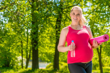 Fototapeta premium Horizontal portrait of a happy pregnant woman after exercising i