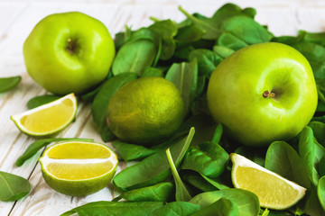 Wooden backgroung with healthy green spinach, lime and apple
