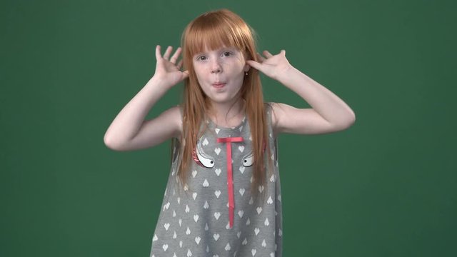 Cute ginger girl playing the ape against chroma key green screen background