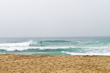 A surfer rides the waves of the ocean.