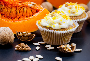 pumpkin cupcakes with cream and pumpkin on a table