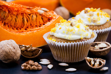 pumpkin cupcakes with cream and pumpkin on a table