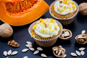 pumpkin cupcakes with cream and pumpkin on a table