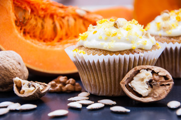 pumpkin cupcakes with cream and pumpkin on a table