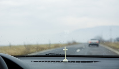 White cross on the car dashboard near the windshield