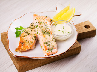 Baked salmon with parmesan and herbs, lemon and sauce.