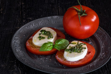 Caprese salad with mozzarella cheese, tomatoes and basil