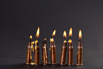 Burning candles and empty rifle cartridges.