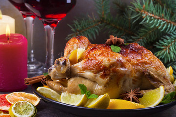 Festive Christmas turkey baked with orange, lemon and lime. Glasses of red wine and candles