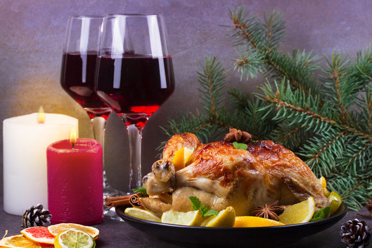 Festive Christmas turkey baked with orange, lemon and lime. Glasses of red wine and candles