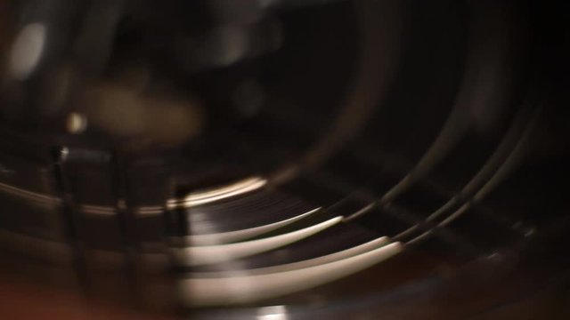 Blurred detail of projector film reel spool running with super 8 filmstrip
