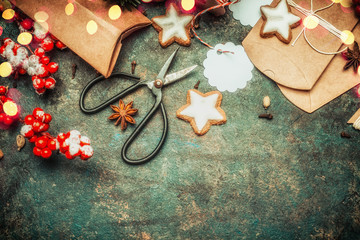 Christmas gifts wrapping with brown cardboard boxes , shears, holiday star cookies and festive decorations, top view, border
