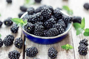 Bowl with fresh blackberries on wooden table