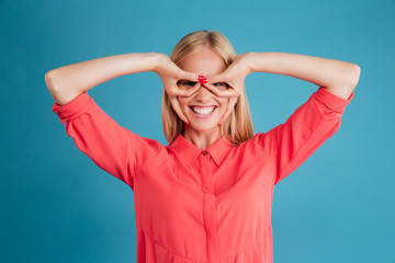 Portrait of a smiling girl looking at camera through fingers