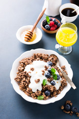 Homemade chocolate granola or muesli with yogurt and fresh blueberries for healthy morning breakfast, selective focus. Healthy food background with copy space for text.