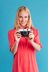 Portrait of a smiling blonde woman holding retro camera © Drobot Dean